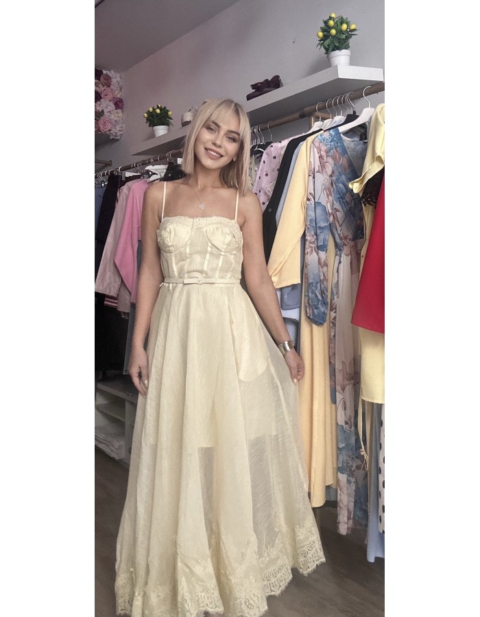   τιράντες και ενισχυμένο μπούστο τύπου κορσέ που αγκαλιάζει υπέροχα το σώμα, ενώ η διακριτική ζώνη στη μέση τονίζει τη σιλουέτα. Η ανάλαφρη φούστα με διαφάνειες και δαντελένιες λεπτομέρειες στο τελείωμα χαρίζει κίνηση και κομψότητα σε κάθε βήμα.