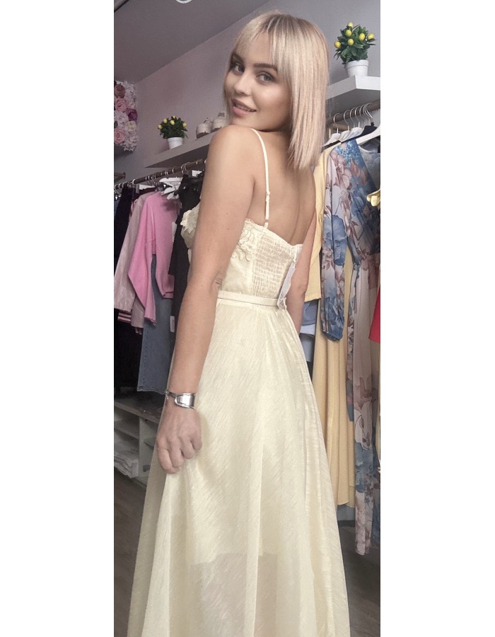   τιράντες και ενισχυμένο μπούστο τύπου κορσέ που αγκαλιάζει υπέροχα το σώμα, ενώ η διακριτική ζώνη στη μέση τονίζει τη σιλουέτα. Η ανάλαφρη φούστα με διαφάνειες και δαντελένιες λεπτομέρειες στο τελείωμα χαρίζει κίνηση και κομψότητα σε κάθε βήμα.