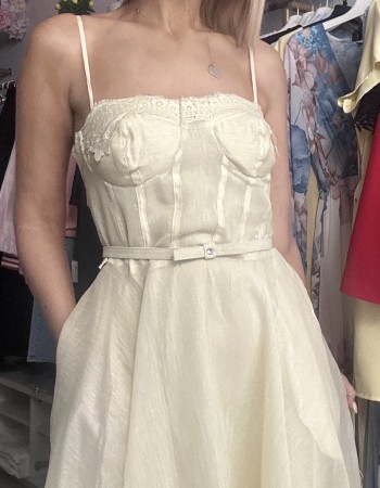   τιράντες και ενισχυμένο μπούστο τύπου κορσέ που αγκαλιάζει υπέροχα το σώμα, ενώ η διακριτική ζώνη στη μέση τονίζει τη σιλουέτα. Η ανάλαφρη φούστα με διαφάνειες και δαντελένιες λεπτομέρειες στο τελείωμα χαρίζει κίνηση και κομψότητα σε κάθε βήμα.