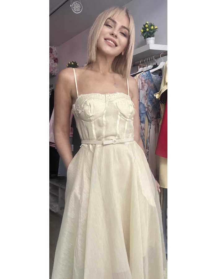   τιράντες και ενισχυμένο μπούστο τύπου κορσέ που αγκαλιάζει υπέροχα το σώμα, ενώ η διακριτική ζώνη στη μέση τονίζει τη σιλουέτα. Η ανάλαφρη φούστα με διαφάνειες και δαντελένιες λεπτομέρειες στο τελείωμα χαρίζει κίνηση και κομψότητα σε κάθε βήμα.